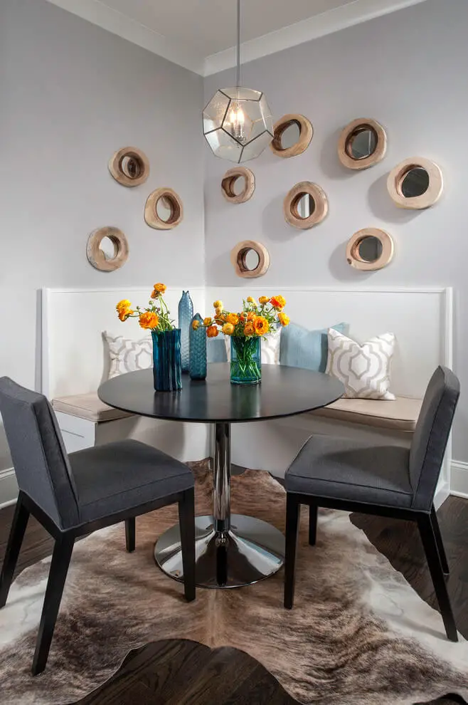 A collection of rustic round mirrors and a hide rug are among the features of this kitchen eating area in Chicago