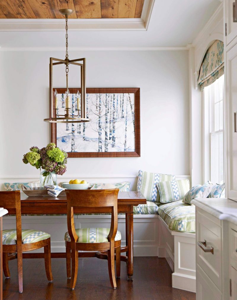 A custom banquette is paired with an antique table and chair in this Westchester, Connecticut, kitchen corner