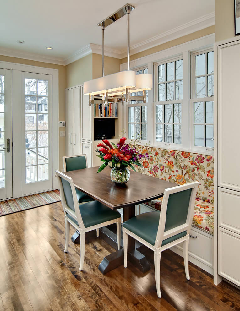 A floral patterned fabric on the banquette and dark teal leather dining chairs make for a sophisticated breakfast nook in Minneapolis