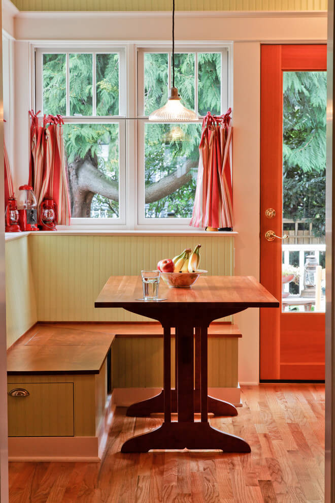 A trio of red lanterns complements the beadboard banquette painted in Benjamin Moore’s Pale Sea Mist in this rustic Seattle kitchen