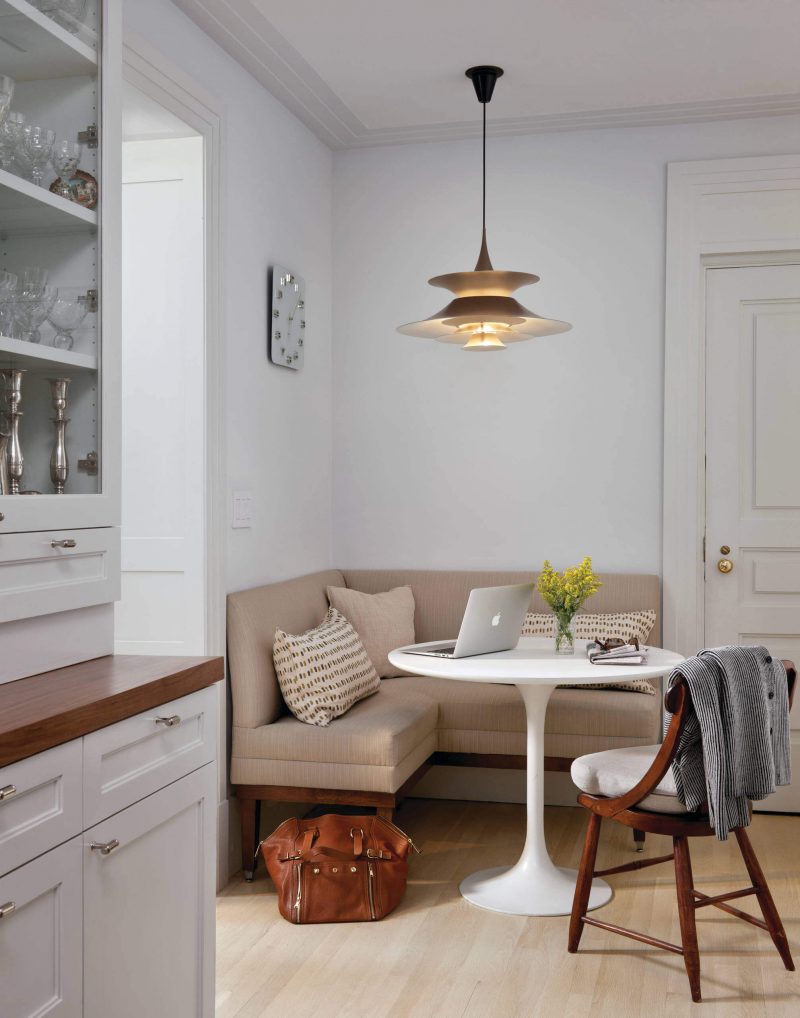 A vintage smoky glass pendant from Paris combined with a classic white Saarinen dining table creates a modern breakfast nook in this New York City home