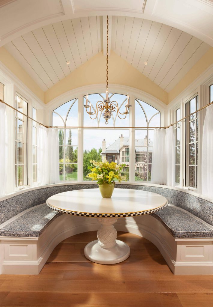 An arched ceiling designed by Think architecture Inc., with a chandelier, makes for an elegant breakfast nook in Salt Lake City