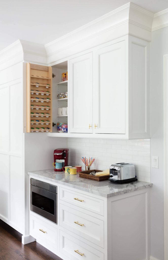 JWH Design and Cabinetry attached a custom coffee pod holder to the inside of the cabinet door in this all-white kitchen in New York.