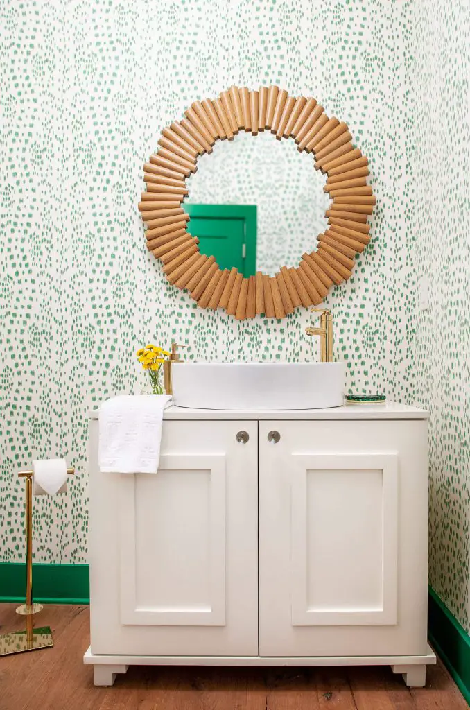 A dresser-turned-vanity, fun wallpaper, and a mirror with a cork frame add to the magic of this Nashville, Tennessee, powder room by Andria Fromm Interiors.