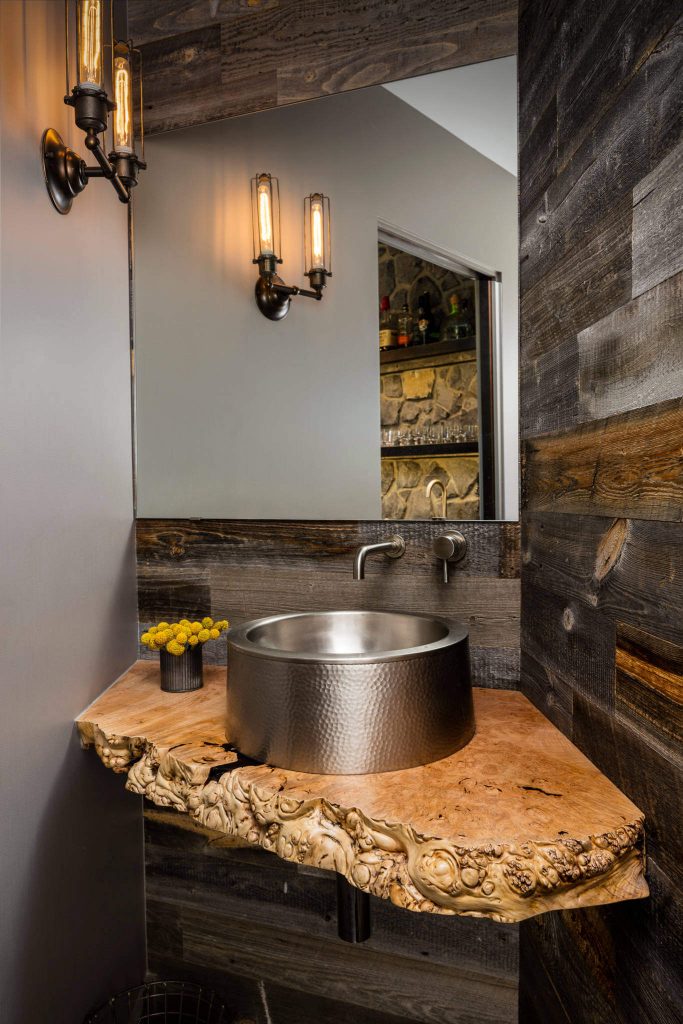 A slab of live-edge oak makes for a dramatic vanity base in this Seattle powder room by Paul Moon Design. The vessel sink atop the base is made of hammered metal.