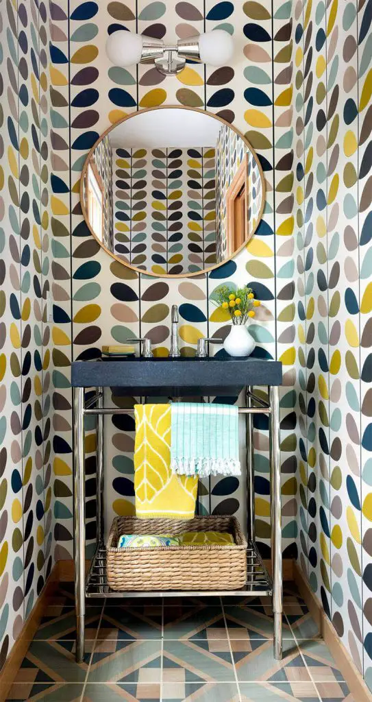 Lucy Interior Design hand-painted the wood floors in this eclectic Minneapolis powder room to make them look like tile. The bold wallpaper adds another splash of whimsy.