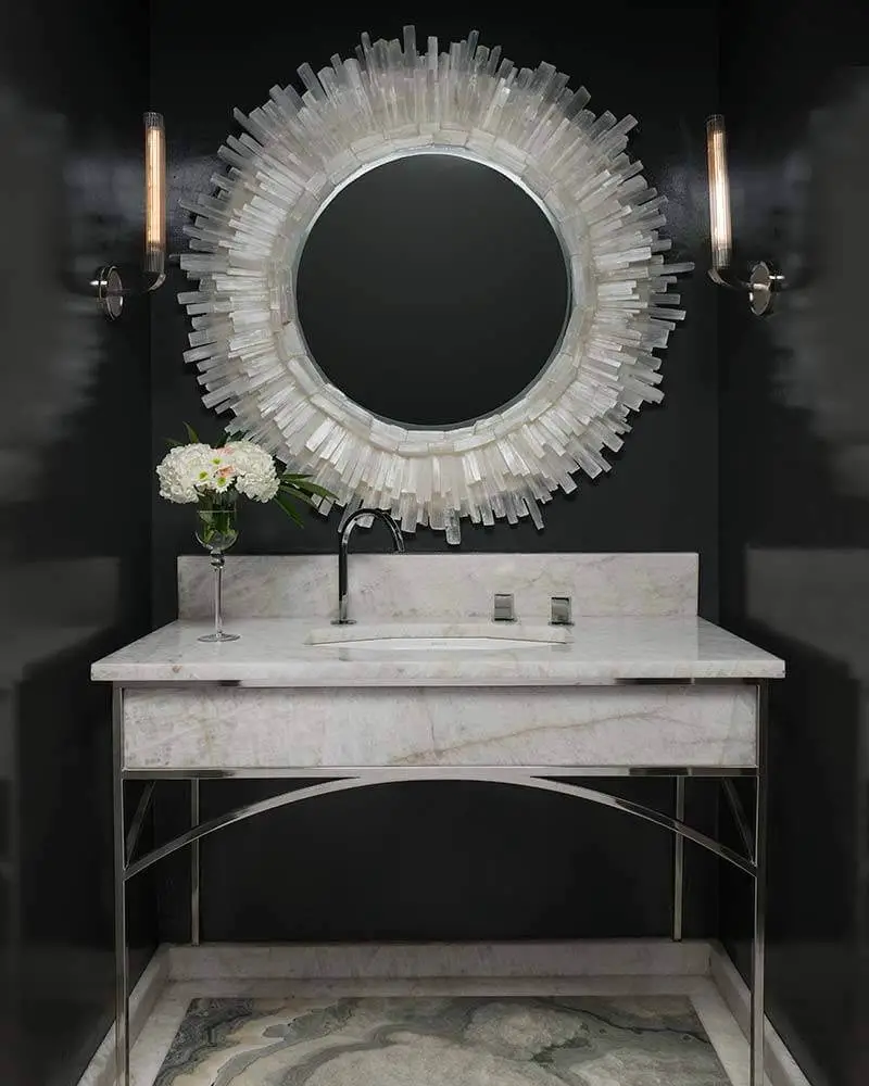 Ventura Custom Homes hung a Dimond Home Shiverpeak mirror with a frame of natural rock crystals on a black lacquered wall here, to glamorous effect.