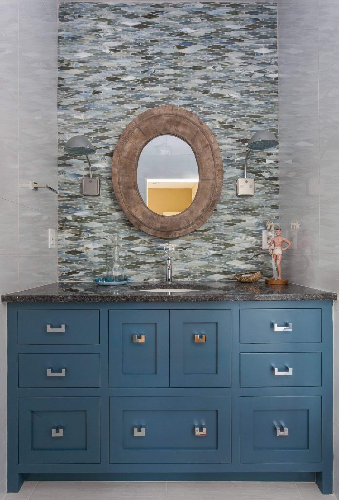 This powder room is on an island off the coast of South Carolina, so the homeowners wanted to infuse it with some coastal charm, including a bright blue vanity and a driftwood mirror. Space was built by the team at Phillip Smith General Contractor.