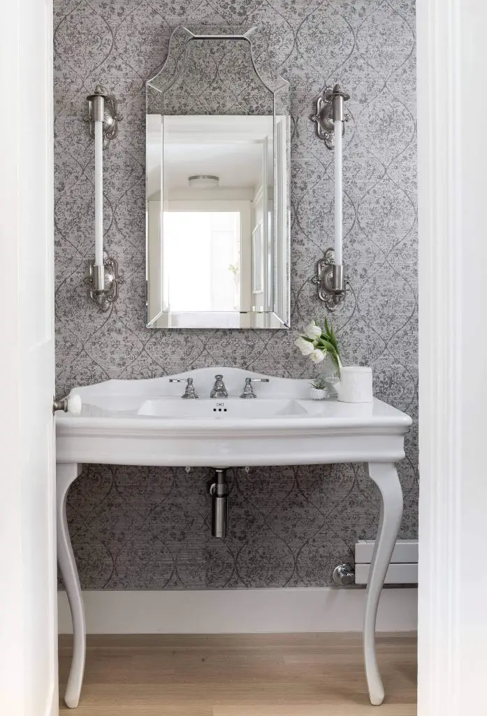 The wall sconces in this Seattle powder room designed by DeForest Architects are a great mixture of classic and contemporary styles, with their ornate nickel elements and sleek light tubes.