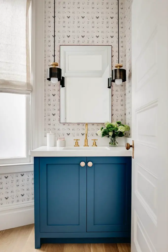 Stylish pendant lights flank the mirror in this hip San Francisco powder room designed by IDF Studio. Note the fun dog-inspired wallpaper too.
