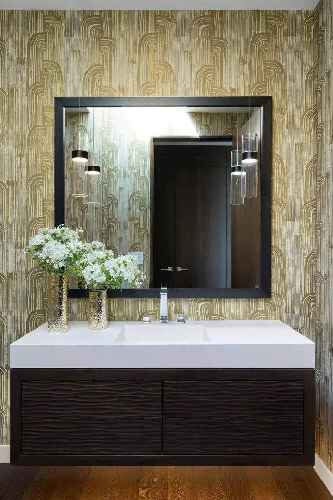 The floating vanity with lights mounted underneath helps keep this stylish Minneapolis powder room by Lucy Interior Design from feeling too heavy.