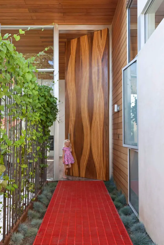 Single front door huge modern single front door idea in Los Angeles with a medium wood front door.