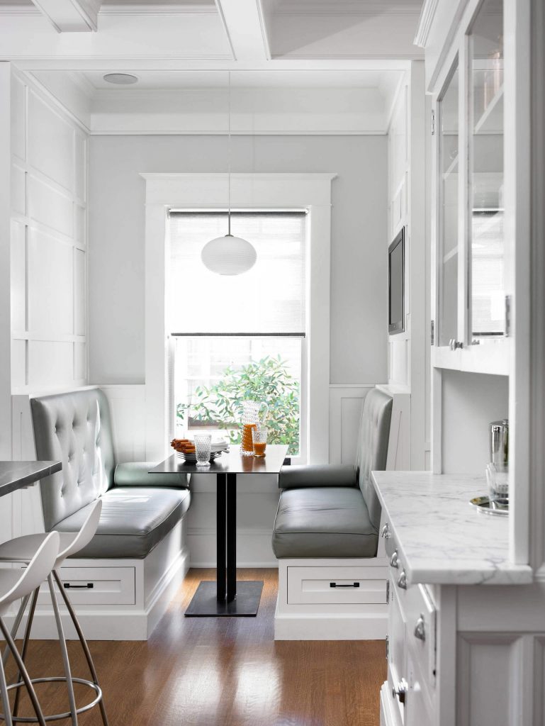 The crisp white and subtle gray veins of the marble countertops are imitated by the colors of the breakfast banquette in this Atlanta kitchen designed by Peachtree Architects