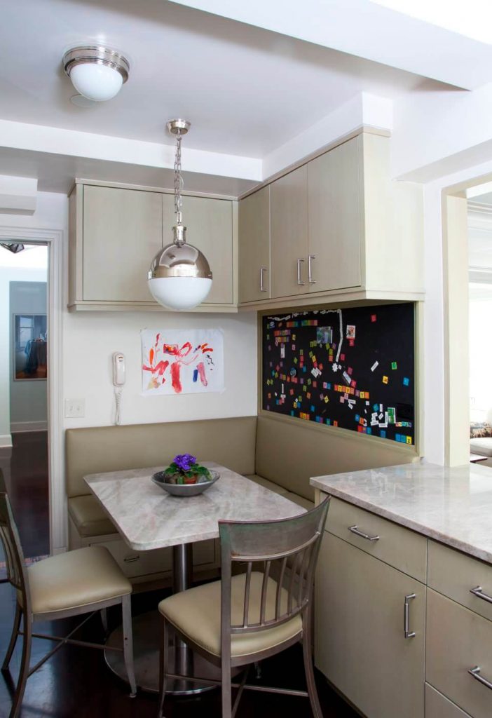 The large Hicks pendant light is an elegant feature in this monochromatic breakfast nook in New York City