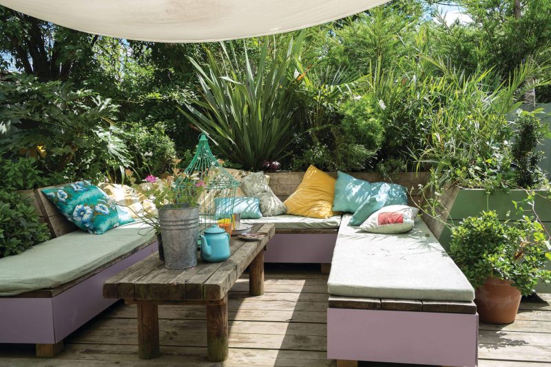 This bohemian outdoor seating area is suited to outdoor entertaining and parties, the seating area is painted in Brassica No.271, while the wooden panels behind are Calke Green No.34.