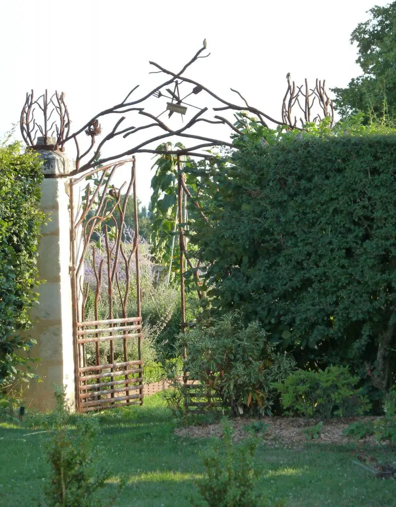 A custom metal gate designed by landscape architect Philippe Dubreuil invites visitors into this garden in Chemilli, France.