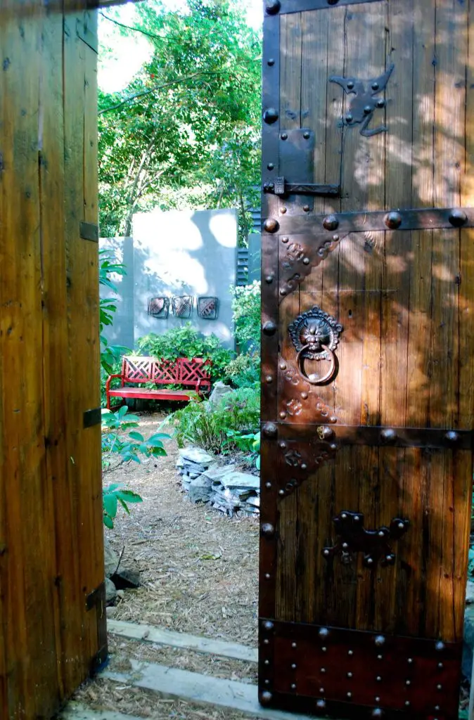A set of Chinese doors marks the entrance to a hosta garden at the top of a koi pond.