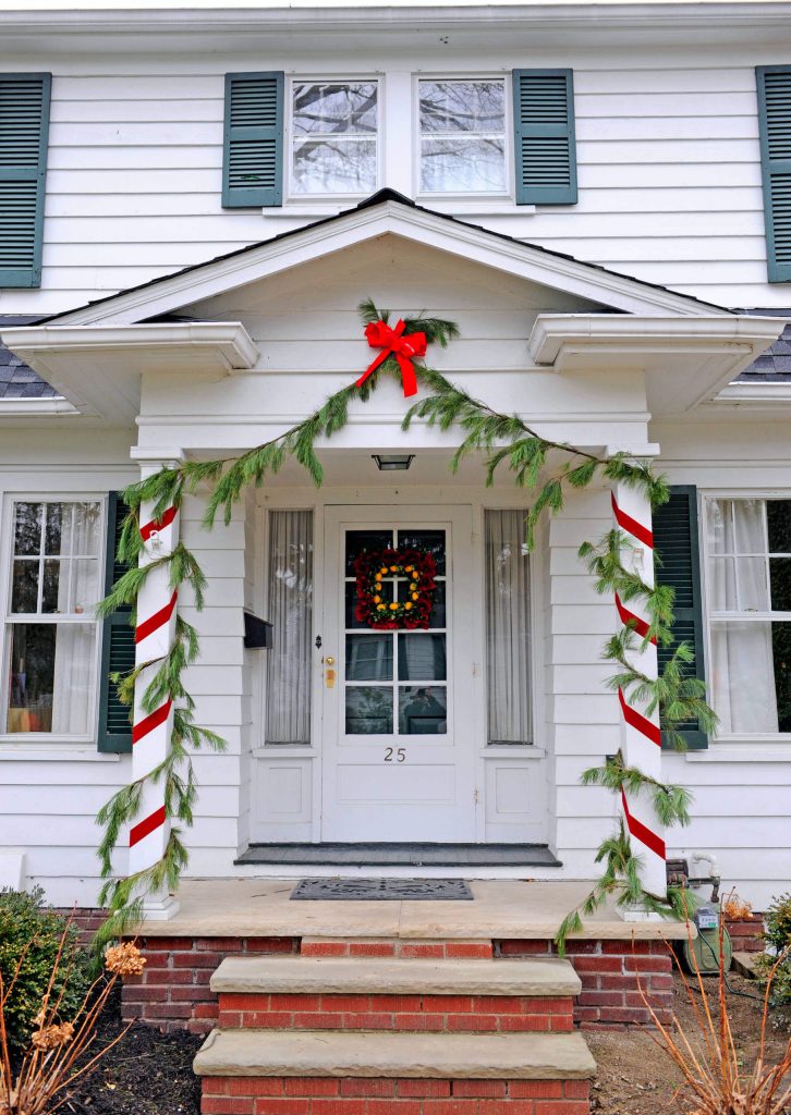 A simple combination of white pine swags and red ribbon has this traditional home all dressed up for the holidays.