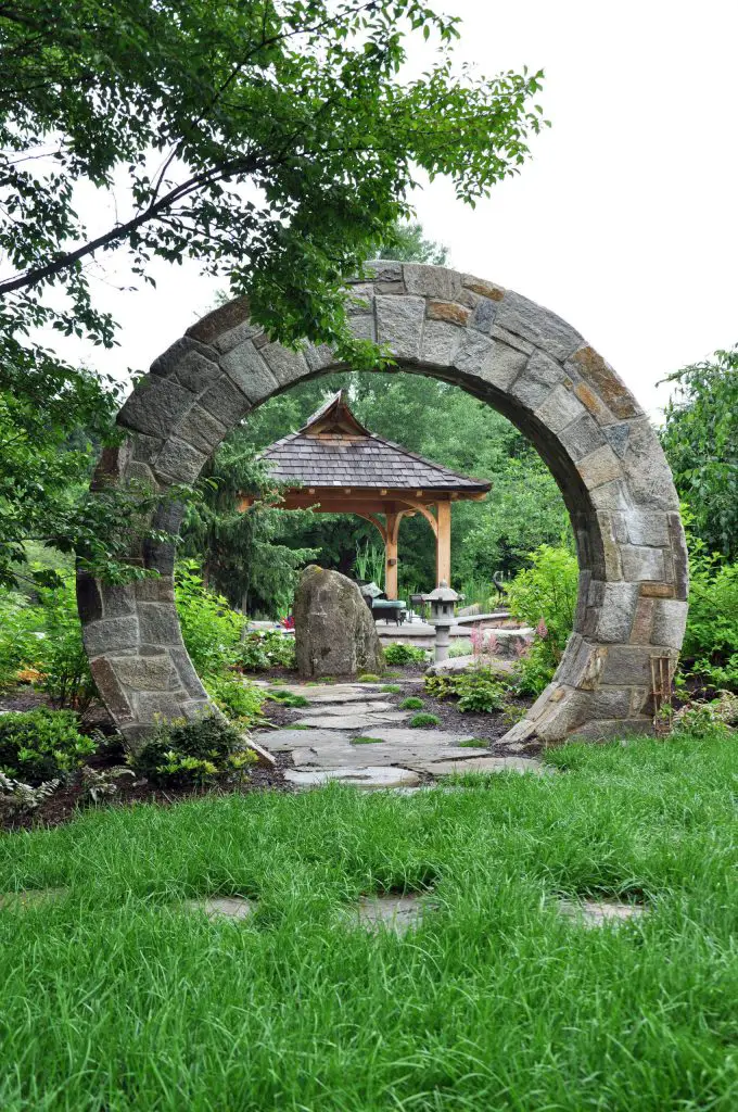 A solid stone moon gate is the primary entry to this garden