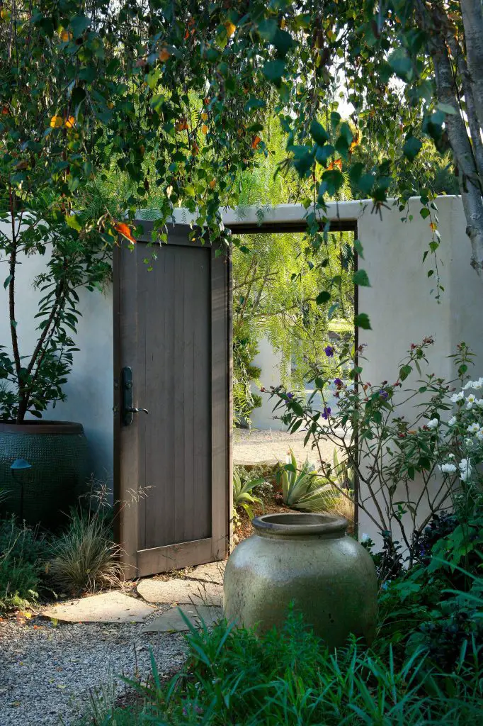 An exterior courtyard wall and door provide a traditional hacienda style entrance in Santa Barbara, California.