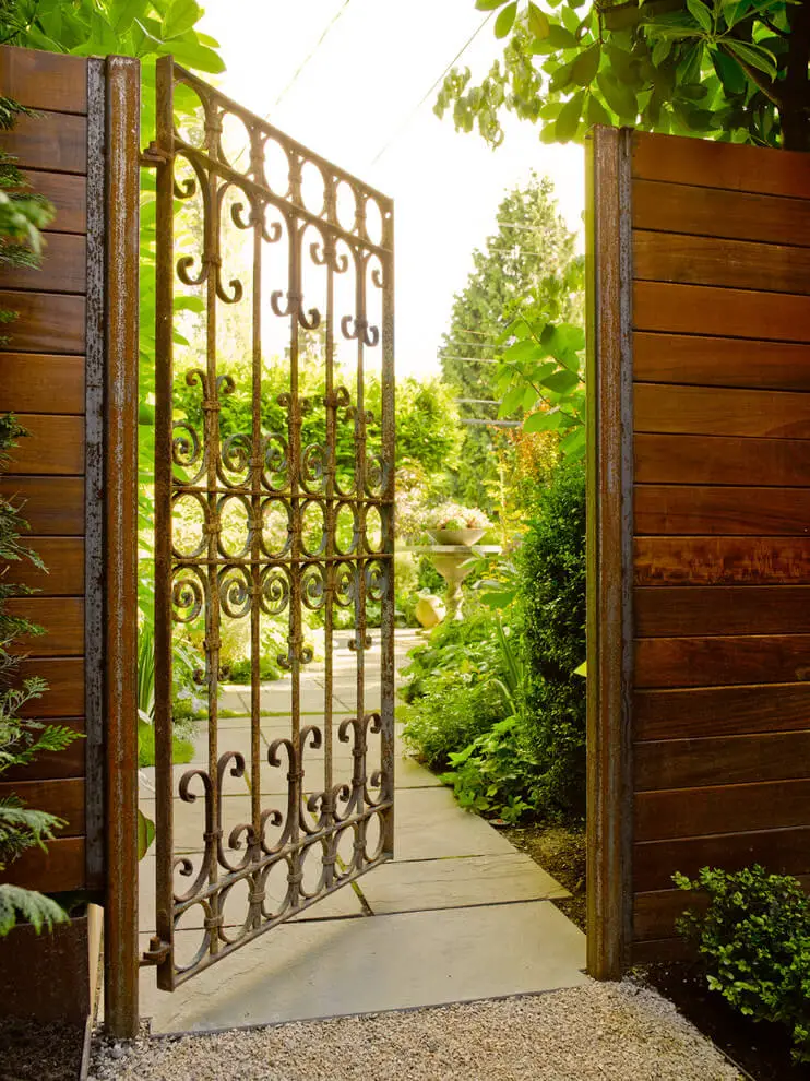 An iron gate with a patina of rust creates an enchanting entrance to this Seattle garden.