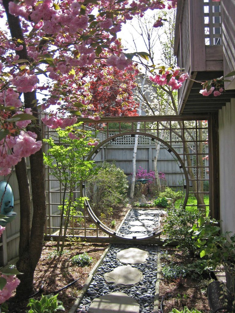 Leonard Design Associates created this moon gate set in a trellis to provide separation between a dining terrace and a small garden beyond.