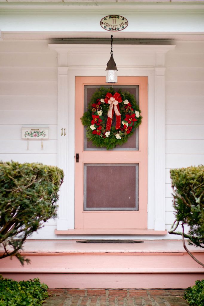 Poinsettia flowers grace the wreath on this front door.