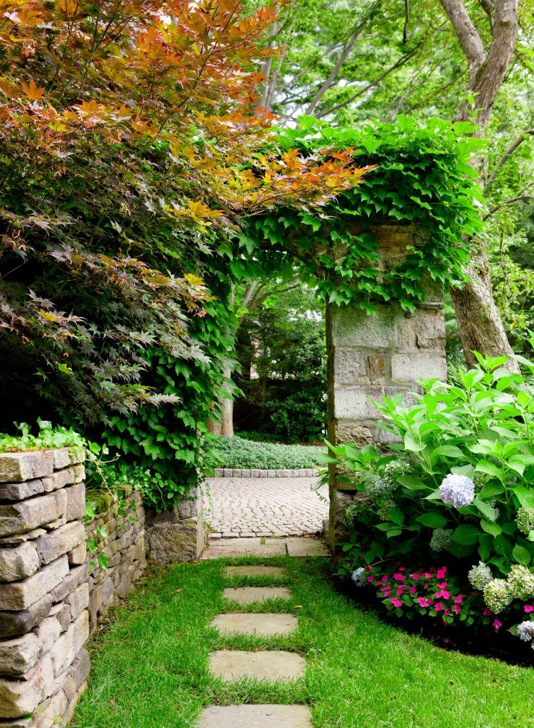 The landscape architects at Sudbury Design Group added masonry walls and a gate to complement a circa 1890 brick home in the Boston area.