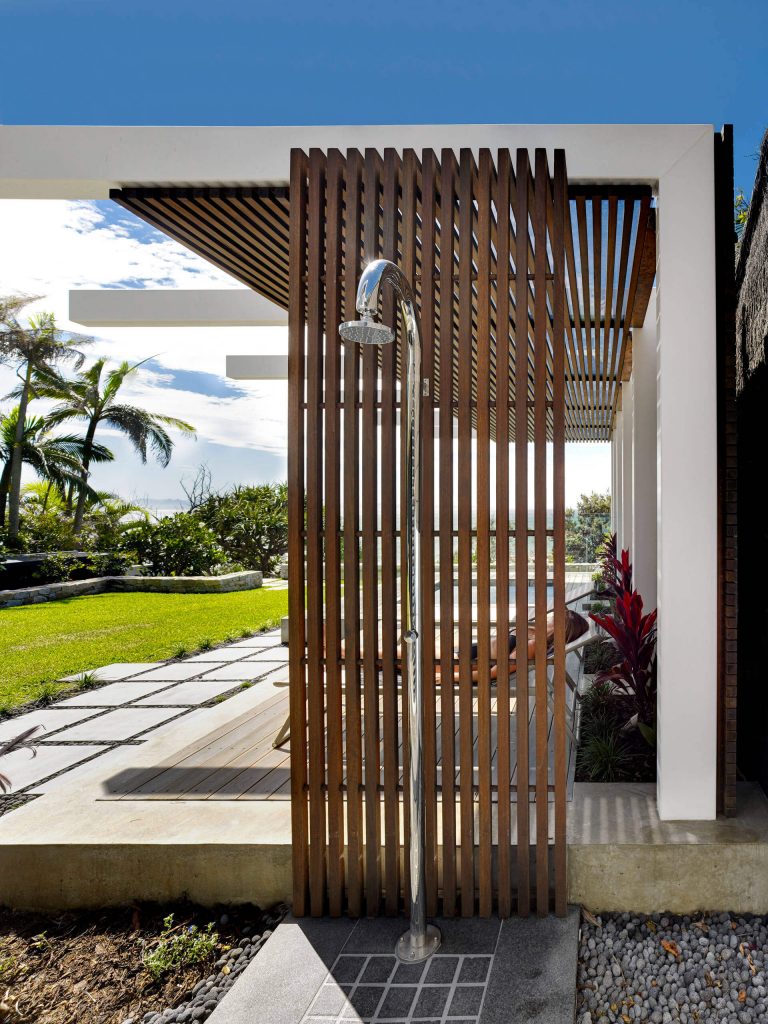 The shower surround’s vertical wood slats mirror