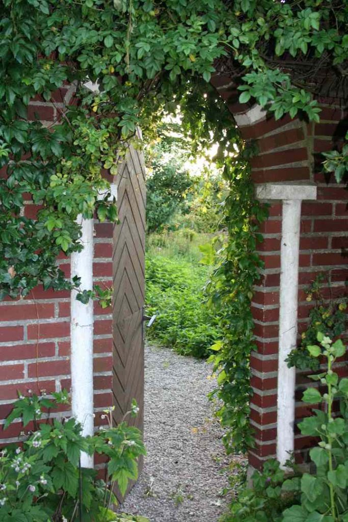 This Swedish country house near the town of Malmo includes a magical garden gate set in an old brick wall.