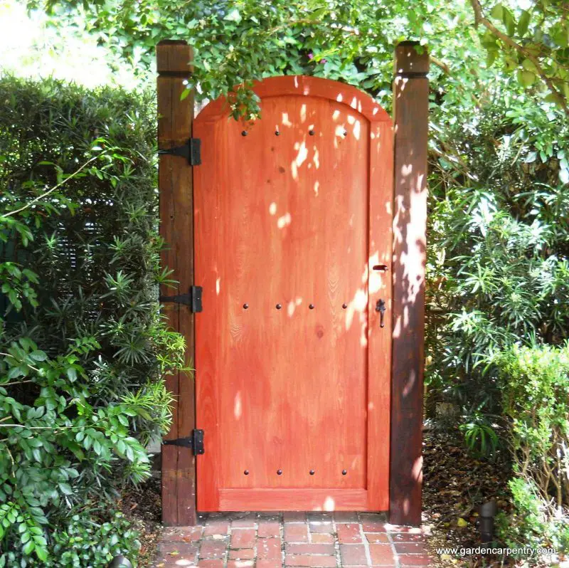 This custom garden gate in Tampa Bay, Florida, has a stain that provides a pop of burnt orange.