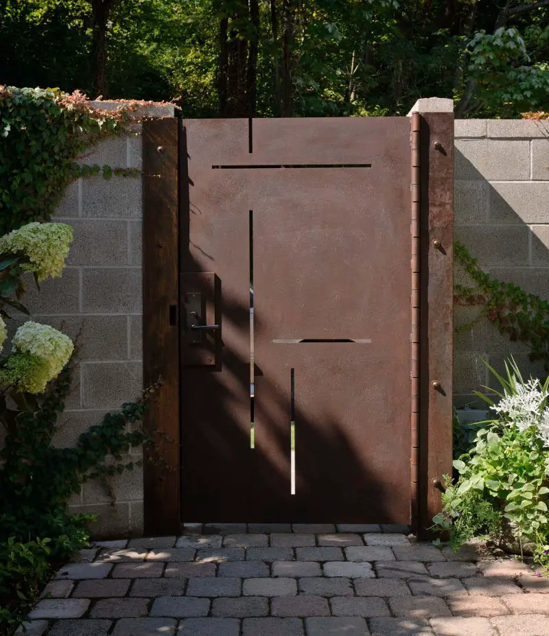 This garden gate in Seattle, designed by Castanes Architects, was custom made with Cor Ten steel and laser cut to create a decorative design.