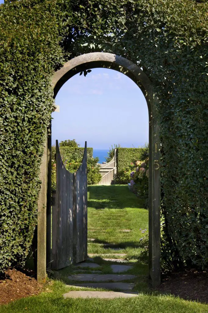 This garden gate surrounded by lush hedges was designed by Ike Kligerman Barkley and leads down to a beach in Nantucket, Massachusetts.
