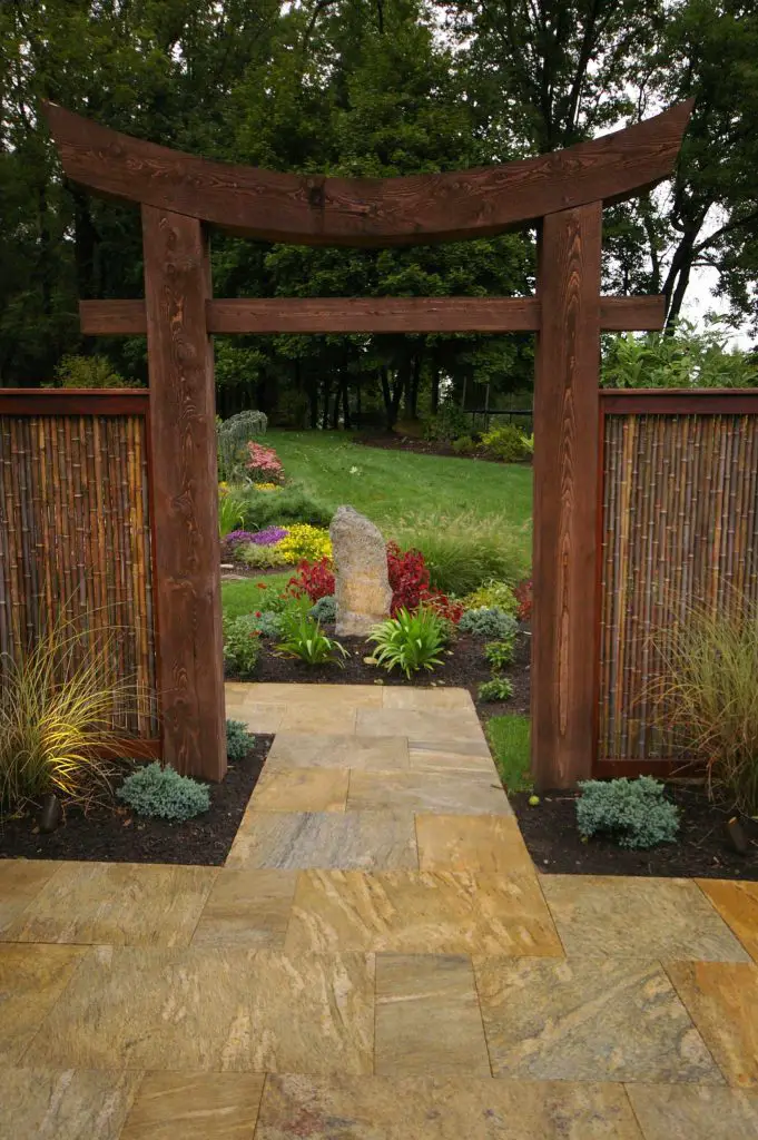 This wooden archway, designed by Environmental Landscape Associates, provides inviting access to the backyard.