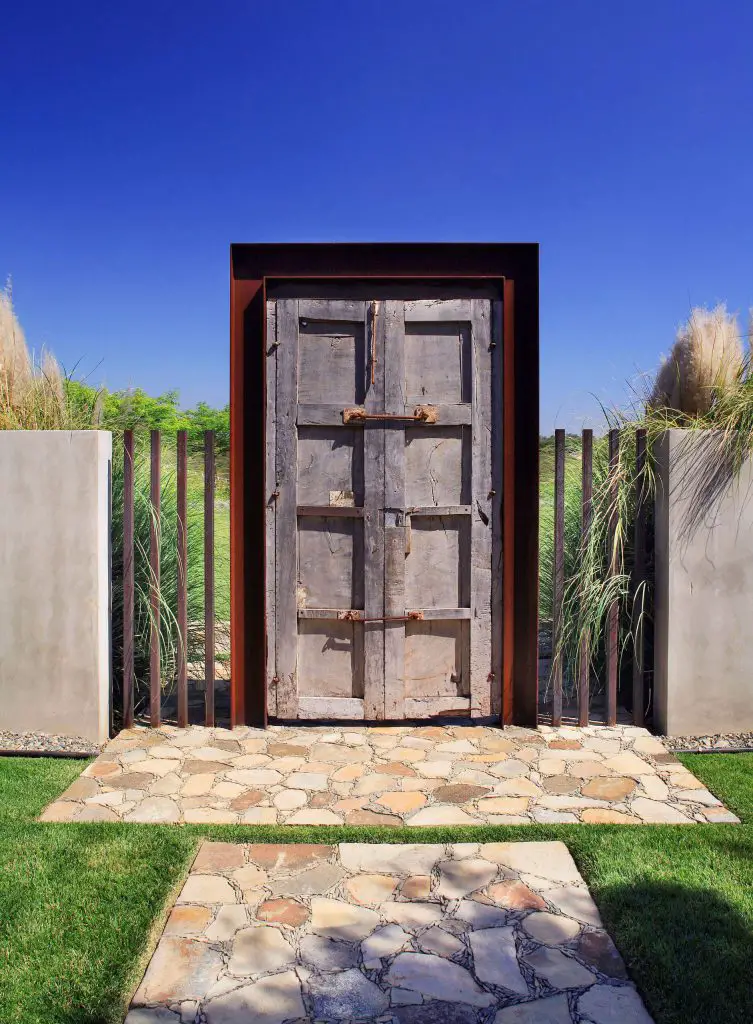 Two hundred year old mesquite doors framed with Cor Ten steel form the entry to this garden courtyard in the Southwest.